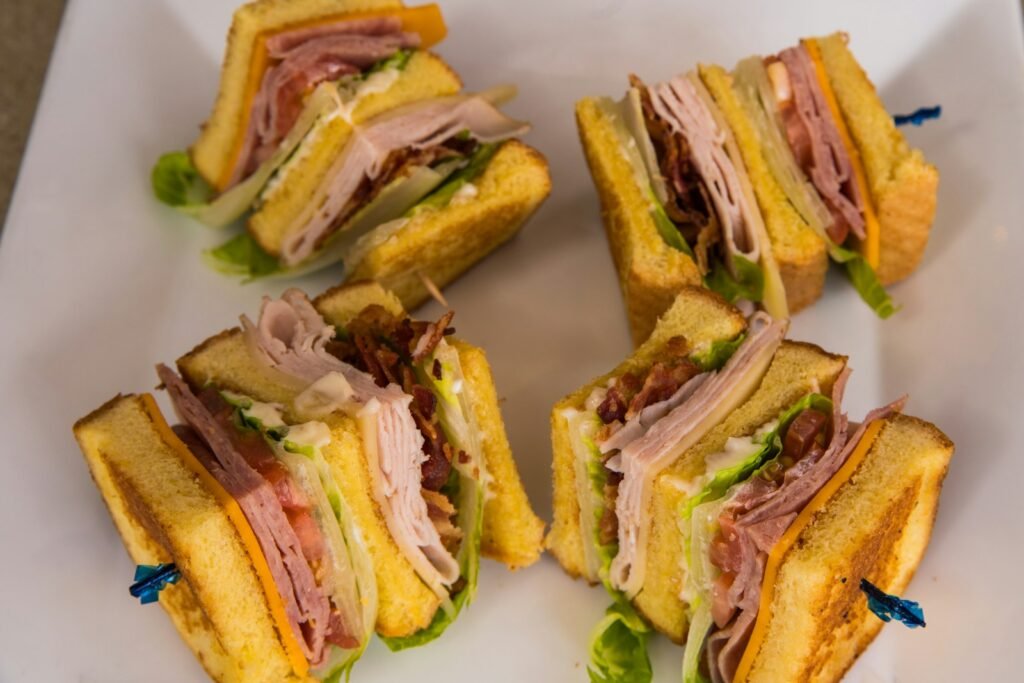 sliced bread with green vegetable on white ceramic plate