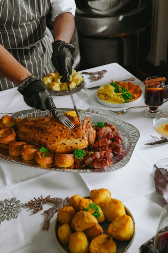 A festive roast dinner featuring seasoned meat, potatoes, Yorkshire puddings, and vegetables, perfect for a cozy meal.