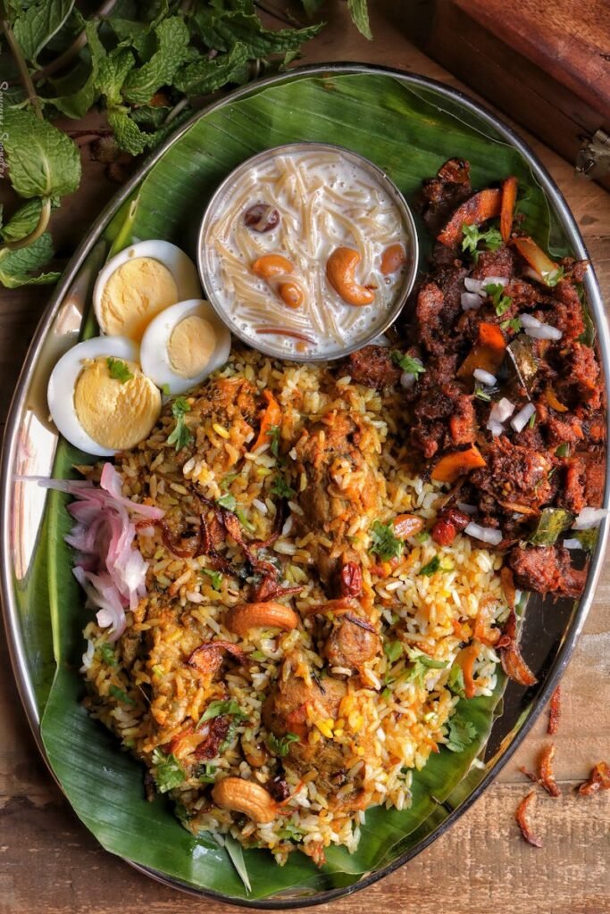 A delicious South Indian biryani with chicken and side dishes served on a banana leaf.