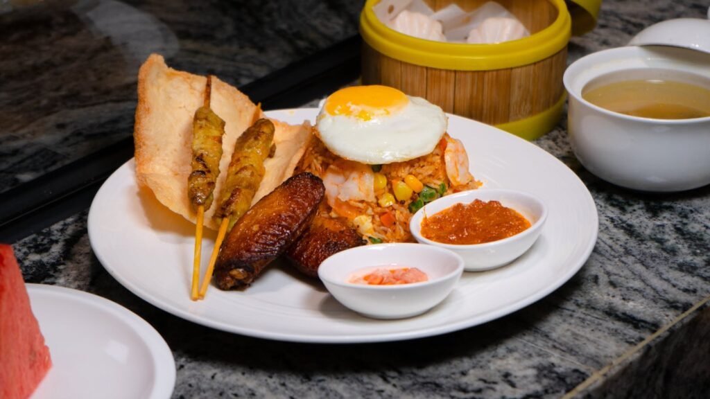 Delicious Indonesian Nasi Goreng served with satay, fried egg, and sambal.