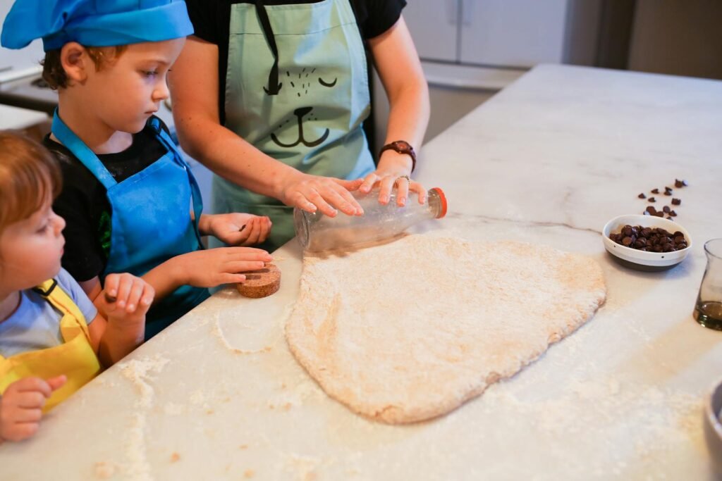 Children and parent making cookies together in a cozy kitchen setting, fostering family bonding time.