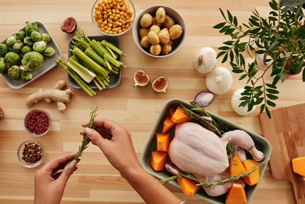 Top view of fresh ingredients and whole chicken ready for roasting, perfect for a homemade meal.