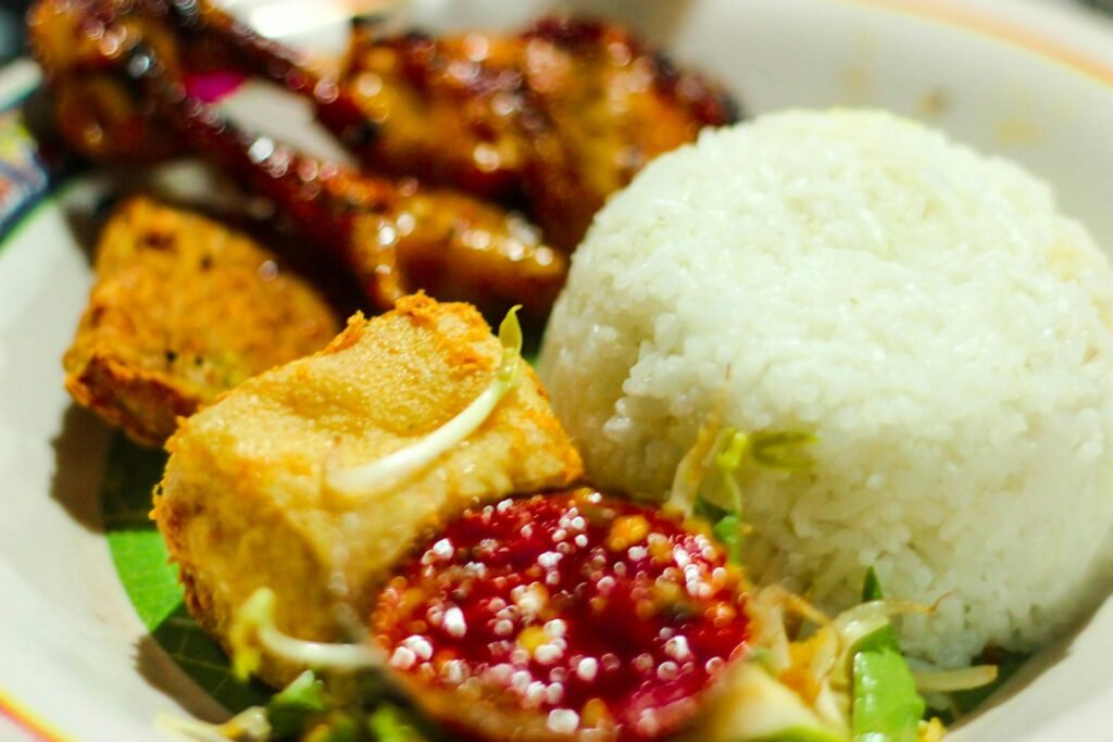 a white plate topped with rice and meat