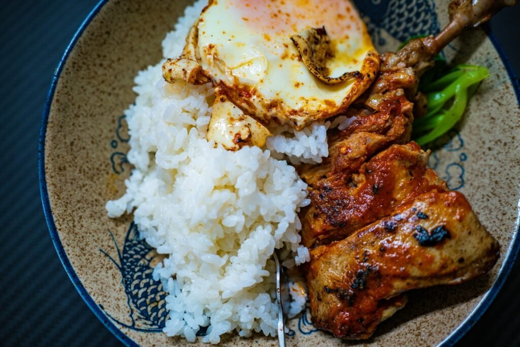 a plate with rice, meat and a fried egg