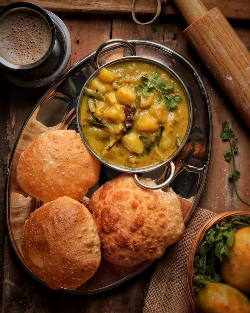 Top view of a traditional potato curry with bread served on a wooden table, perfect for rustic dining.