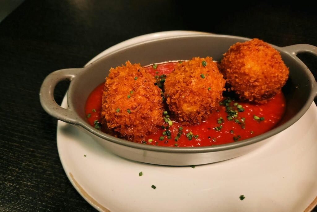 Crispy arancini with tomato sauce are delightful.