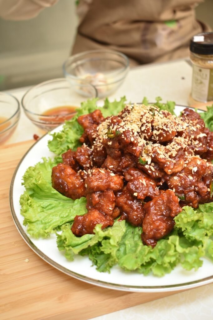 A white plate topped with lettuce covered in meat