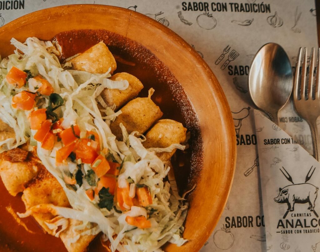 A vibrant plate of Mexican enchiladas topped with fresh lettuce and salsa, perfect for a cultural dining experience.