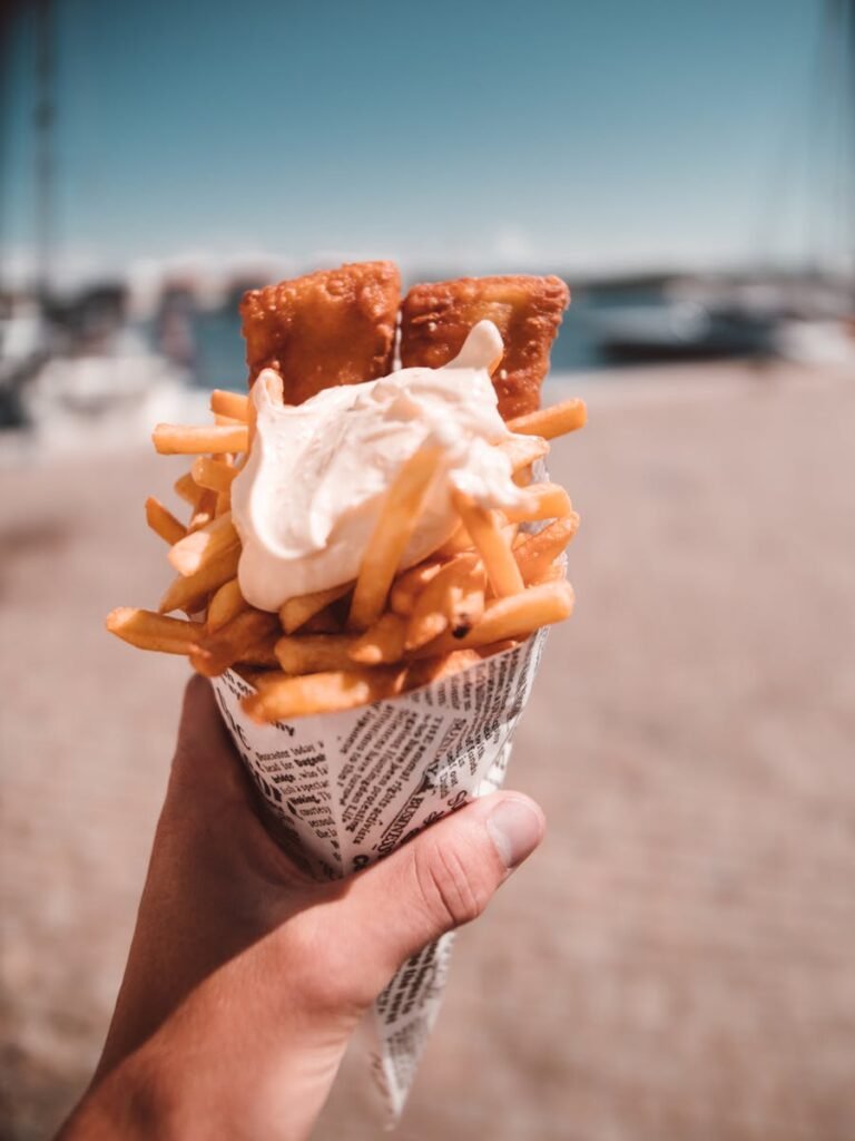 Delicious fish and chips served in a newspaper cone, perfect summer beach food.