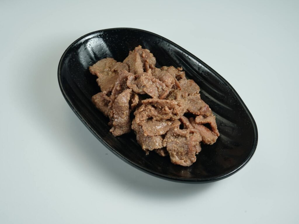 Close-up of sliced marinated Korean bulgogi beef in a stylish black bowl.