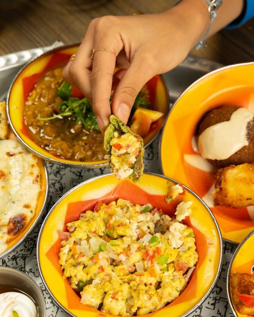 A vibrant spread of traditional Indian dishes with a focus on colorful presentation and rich flavors.