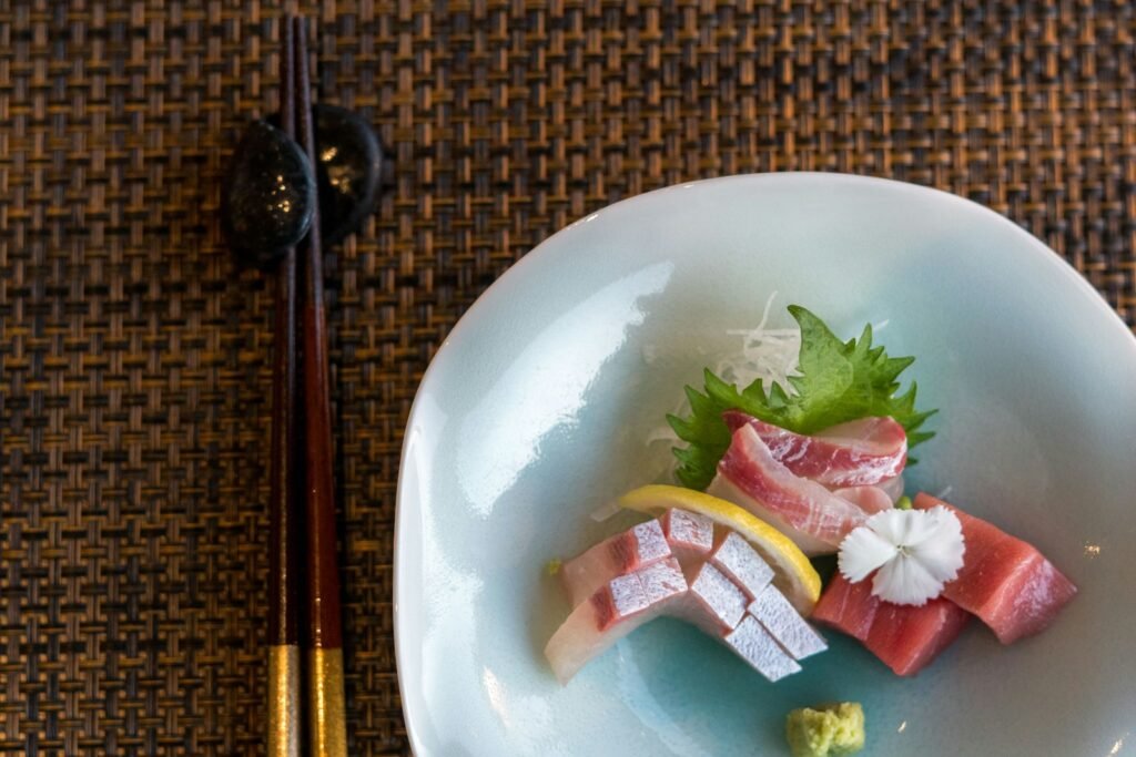 A white plate topped with sushi and chopsticks