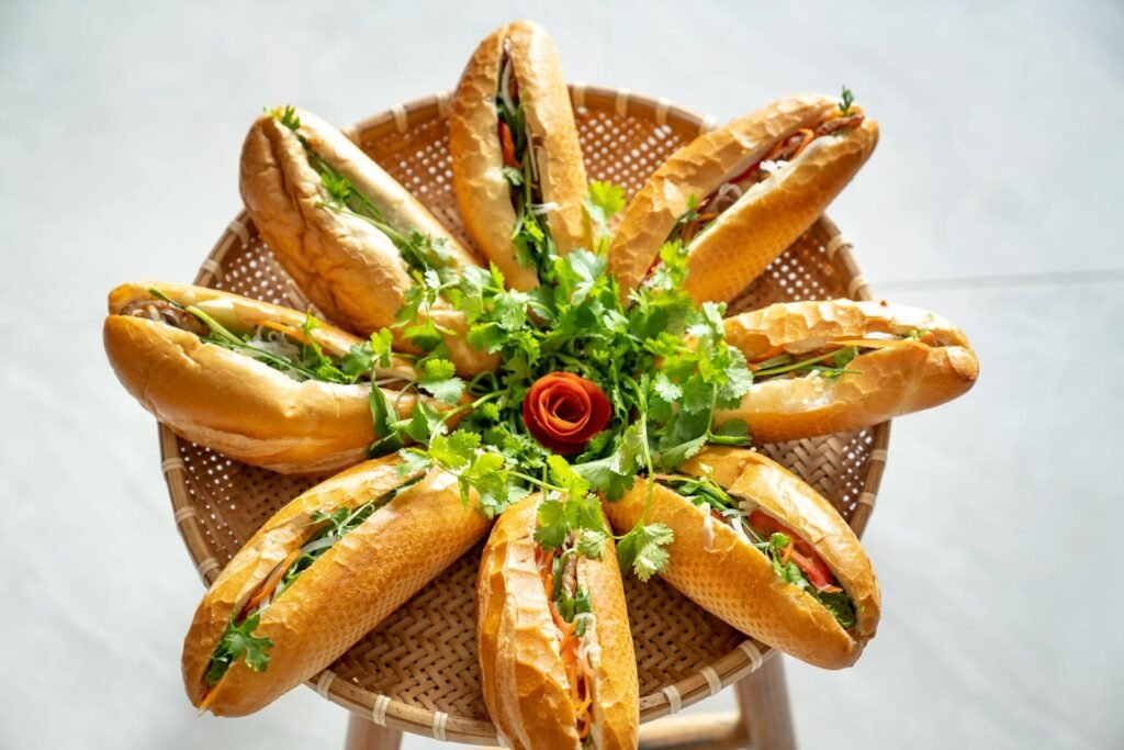 A top view of a decorative arrangement of Vietnamese Banh Mi sandwiches garnished with cilantro and vegetables.