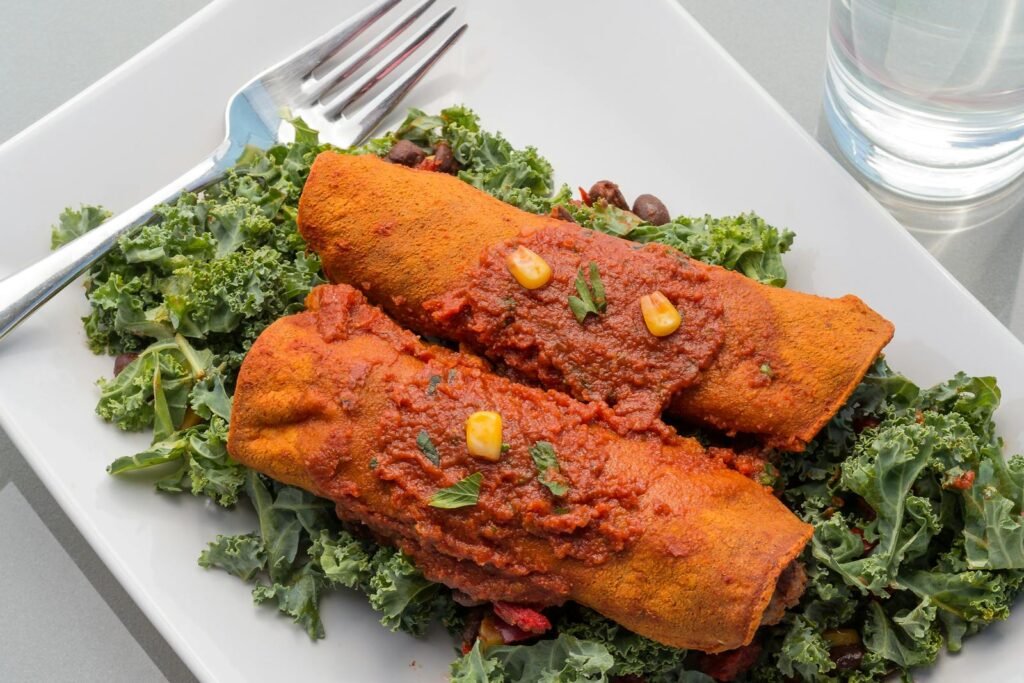 Colorful enchiladas served on a kale salad, perfect for a healthy dinner.