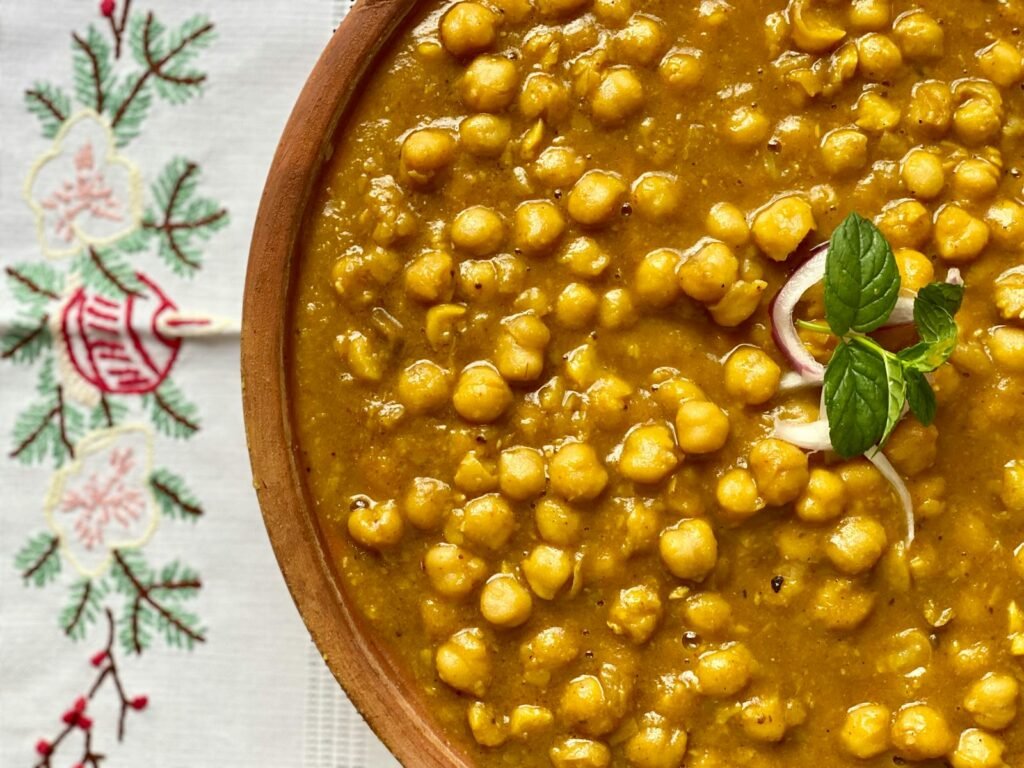 Delicious close-up of Chana Masala, a flavorful Indian dish garnished with mint and onion.
