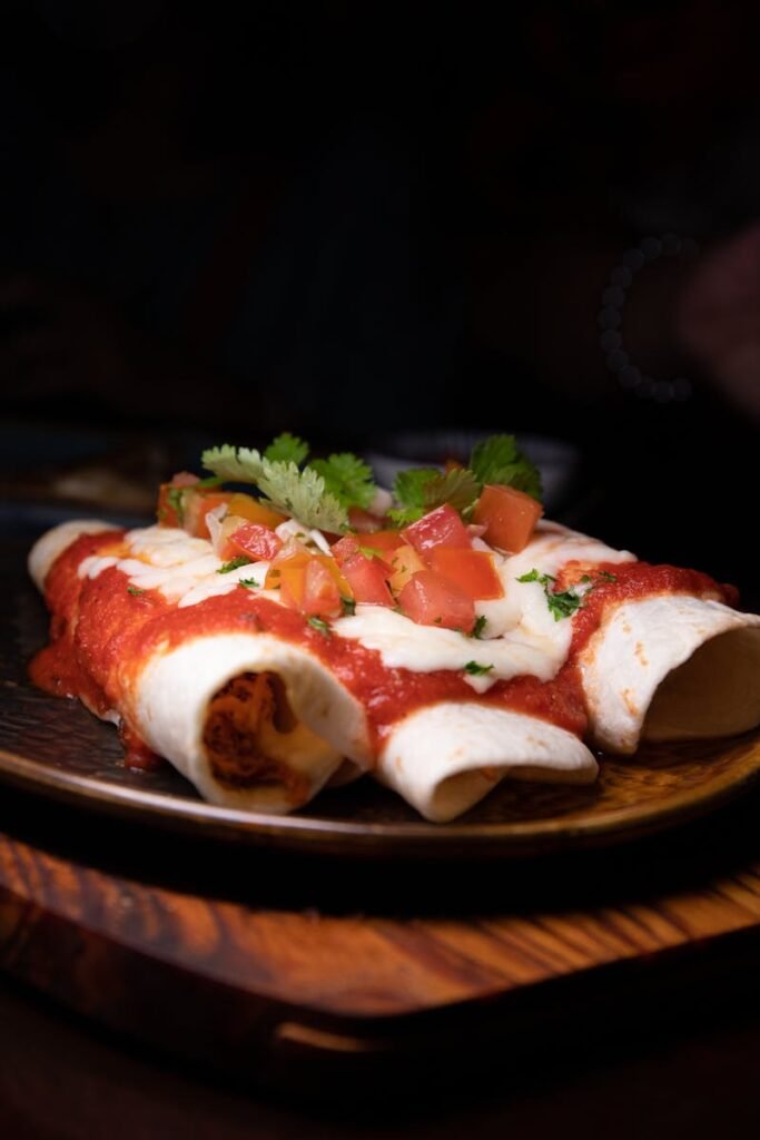 Delicious enchiladas topped with fresh tomato sauce and herbs, perfect for a Mexican meal.