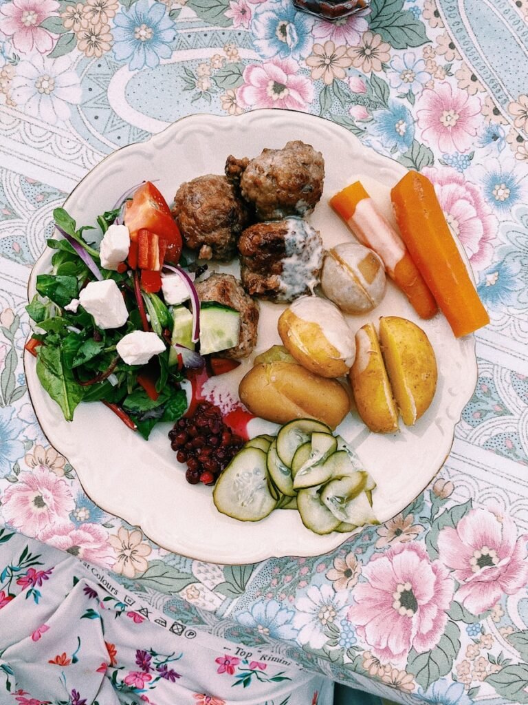 A white plate topped with meat and vegetables
