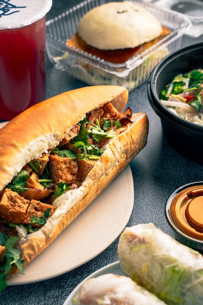 a sandwich with meat, lettuce, and sauce on a plate