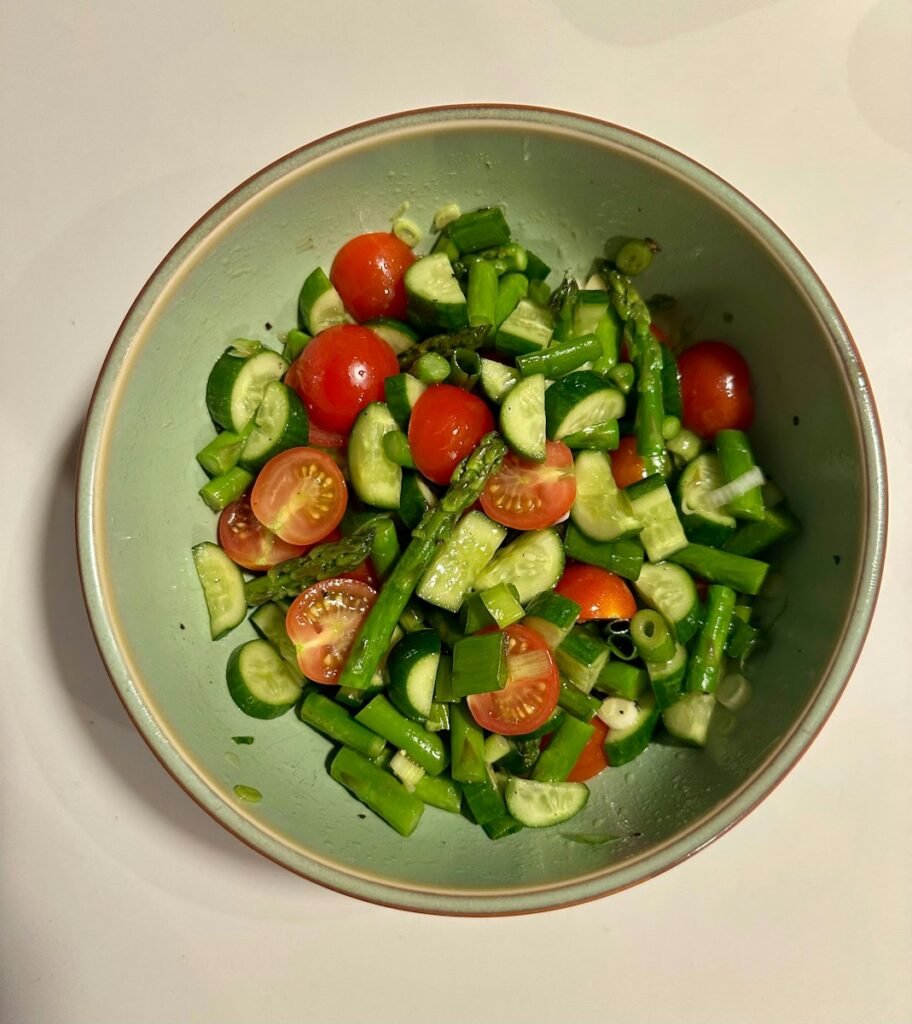 Fresh salad with tomatoes, cucumber, and asparagus.