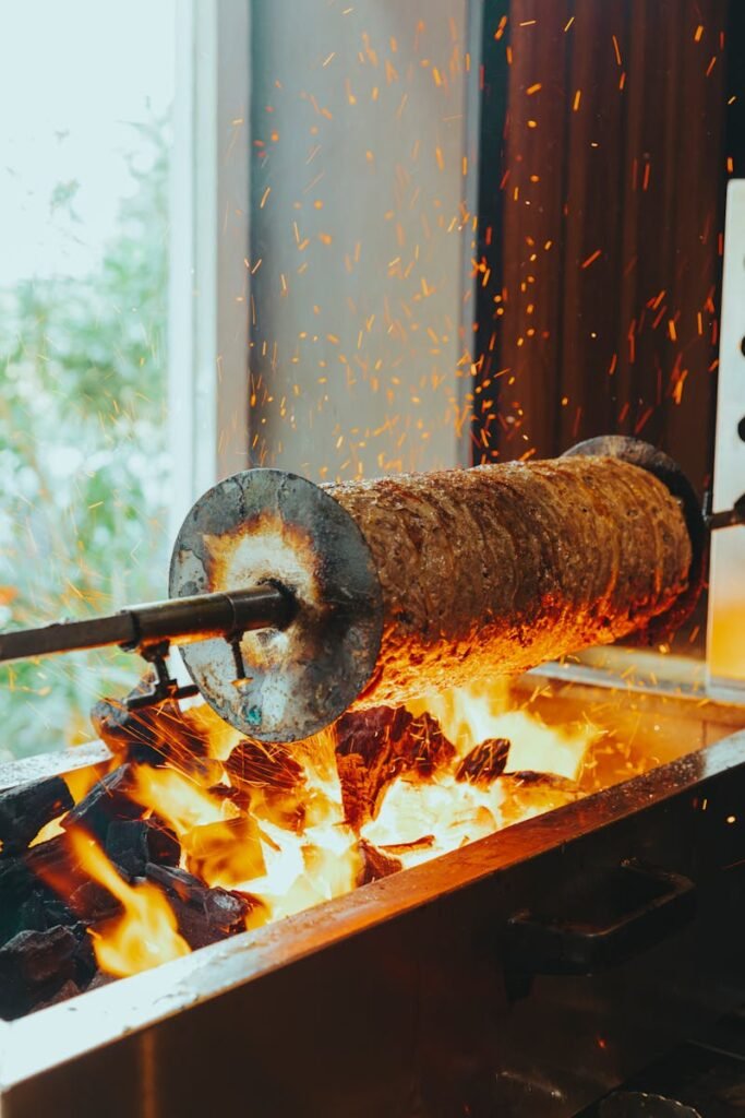 A succulent kebab rotating over open flames in a Baku restaurant, showcasing traditional cooking technique.