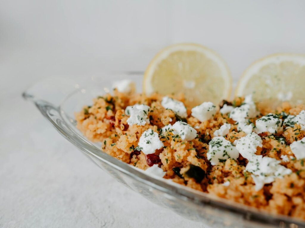 Tasty couscous topped with feta cheese and lemon slices, perfect for a Mediterranean meal.