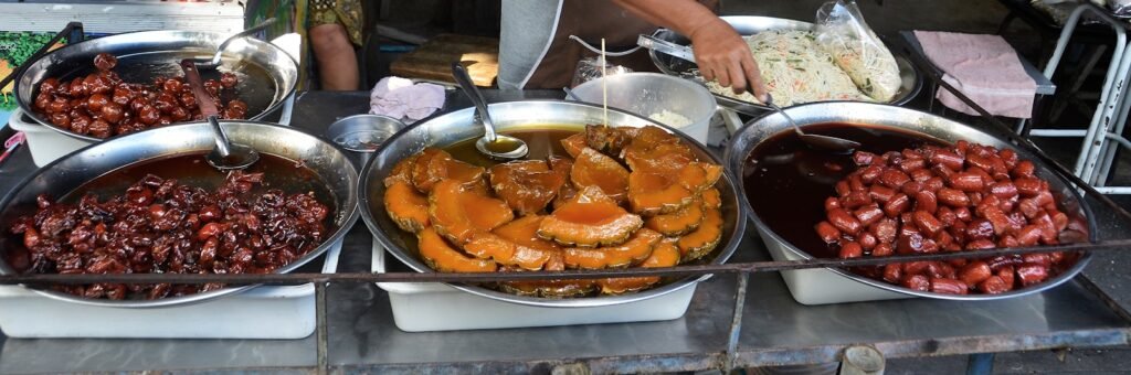 a man standing behind a buffet filled with lots of food