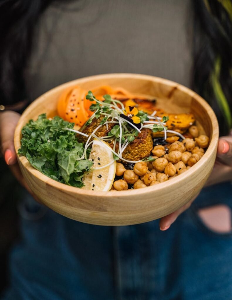 A delicious vegan Buddha bowl featuring chickpeas, kale, lemon, and fresh vegetables, perfect for a healthy meal.