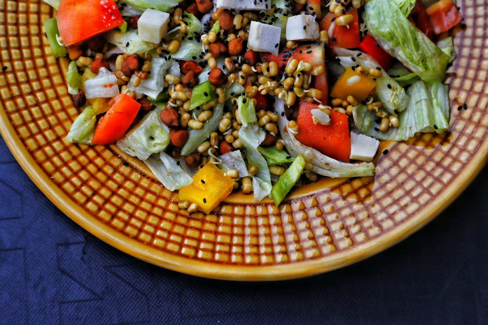 a plate of salad on a blue table cloth